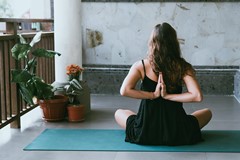 sitting woman with hands in reverse prayer yoga position