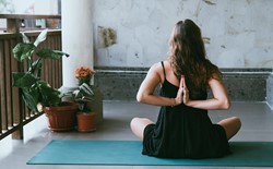 sitting woman with hands in reverse prayer yoga position