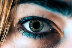 close up of blue eye surrounded by blue eyeliner