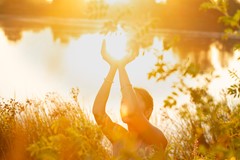 Woman hands in mudra at sunset on the lake in nature