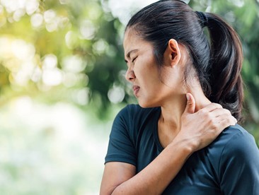 Woman holding side of her neck in pain