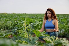 woman meditating in a farmers field