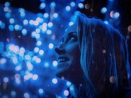 woman smiling in front of blue lights