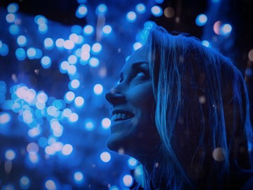 woman smiling in front of blue lights